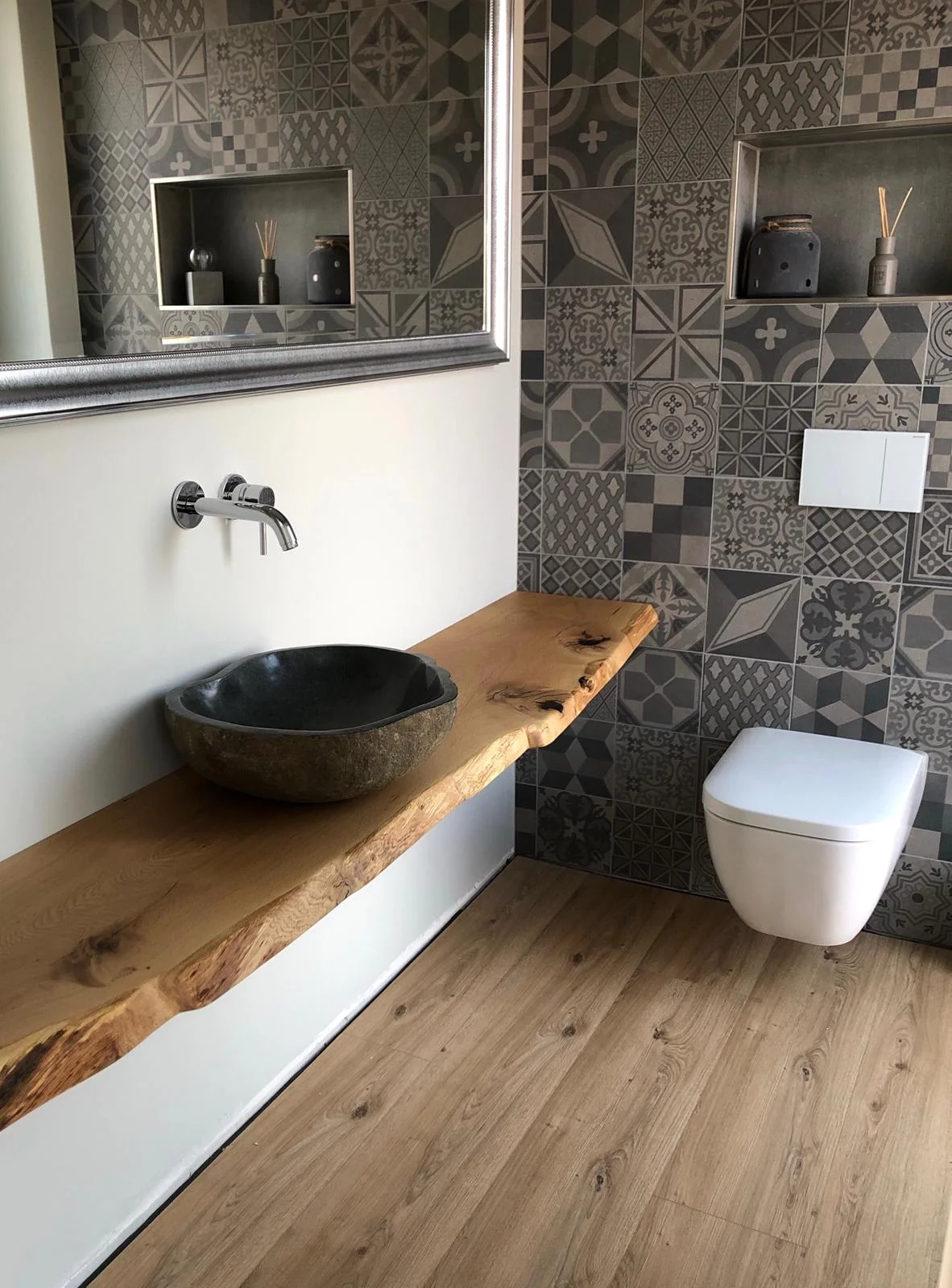 Ein hell-dunkles Badezimmer mit einem Waschbecken aus Stein und Holzboden