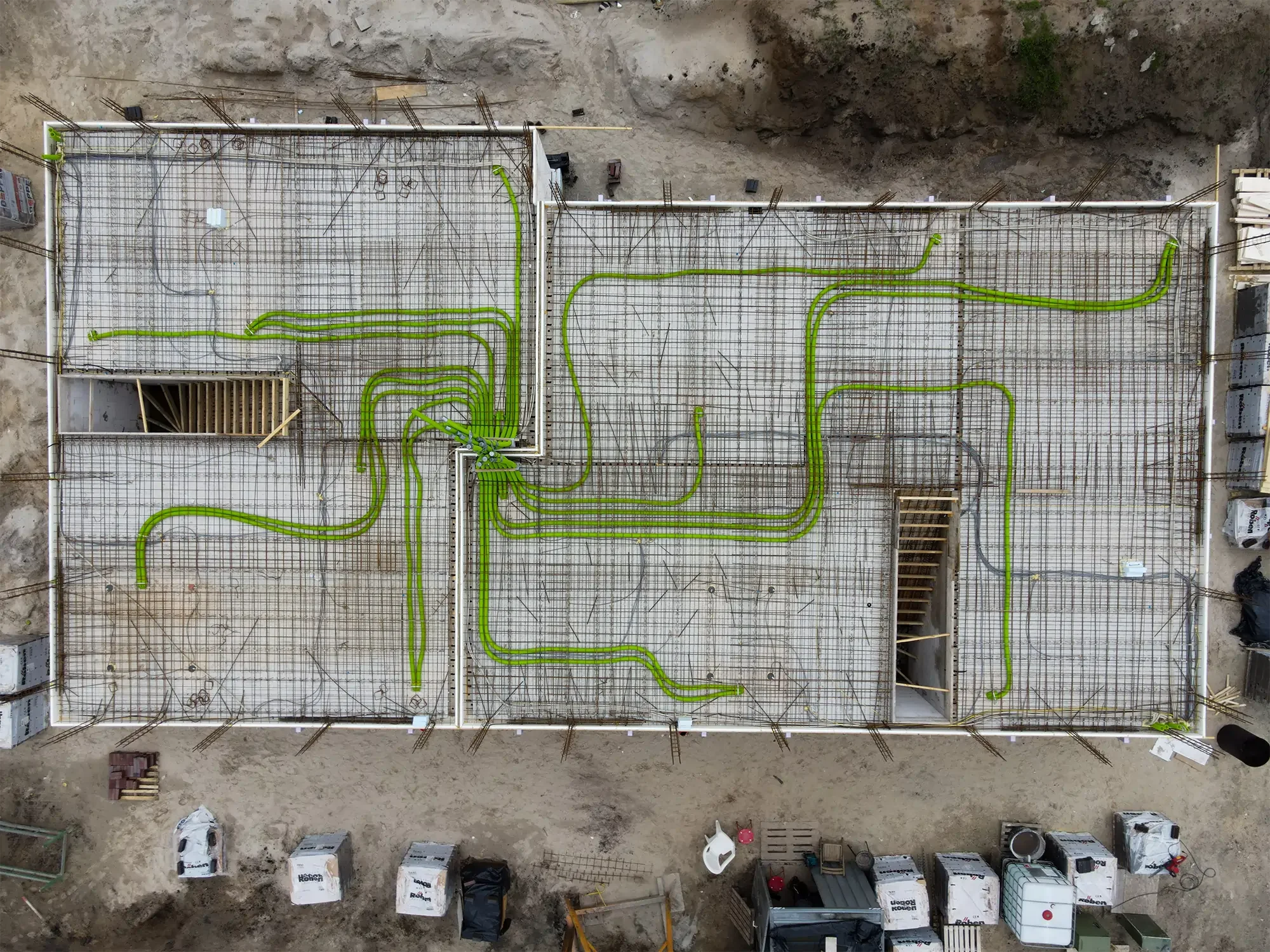 Drohnenaufnahme von einem Gebäude von oben bei dem grüne Lüftungsrohre verlegt sind